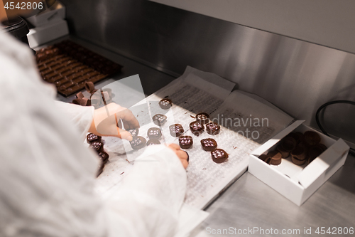 Image of worker packing candies at confectionery shop