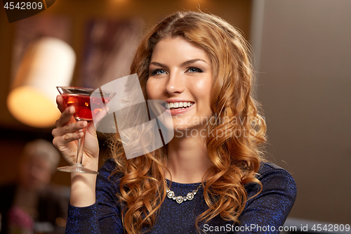 Image of woman with glass of cocktail at night club