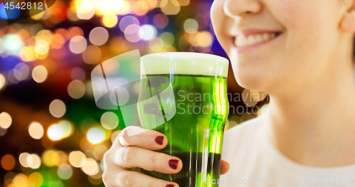 Image of close up of woman with green beer in glass