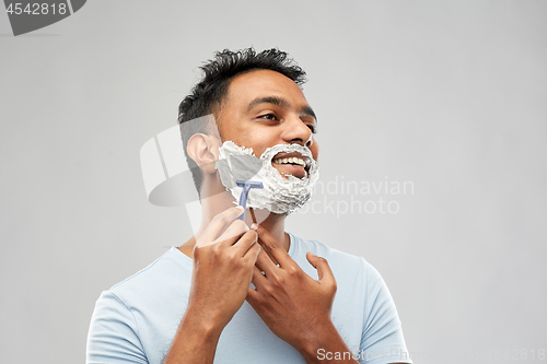 Image of indian man shaving beard with razor blade