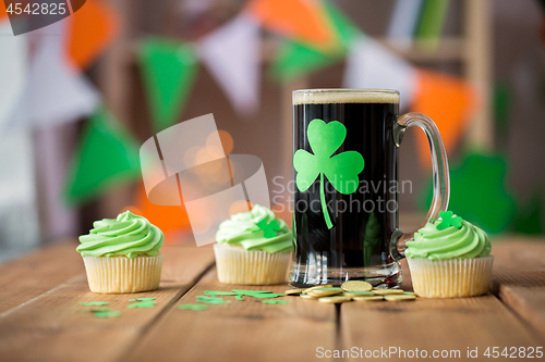 Image of shamrock on glass of beer, green cupcake and coins