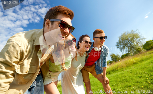 Image of happy teenage friends laughing outdoors in summer