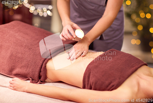 Image of woman lying and having massage with hot oil at spa