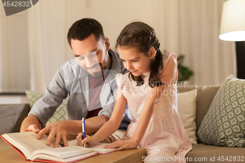 Image of father and daughter doing homework together