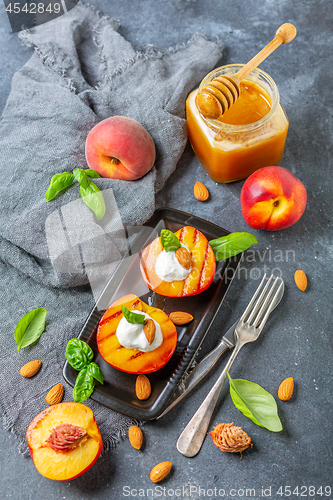 Image of Fresh grilled peaches with honey and green basil.