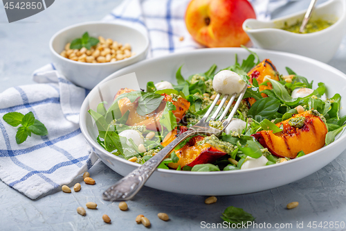 Image of Fresh arugula salad with nectarines and pesto.