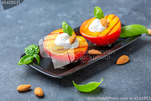 Image of Grilled peach with honey, yogurt and almonds.