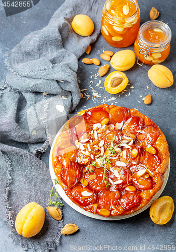 Image of Sliced caramelized tarte tatin pie with apricots.