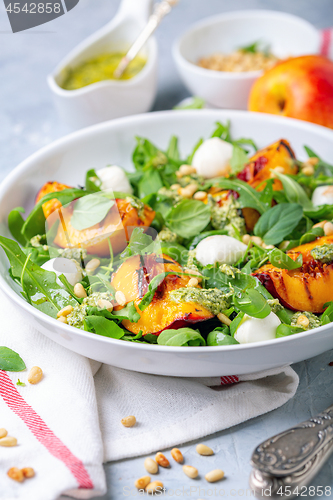 Image of Salad with arugula, nectarines and pesto sauce.