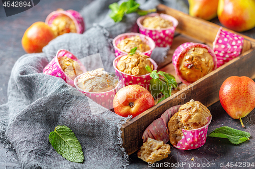 Image of Muffins with pears and muesli in a wooden tray.