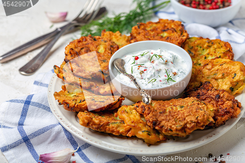 Image of Delicious zucchini fritters with yogurt sauce.