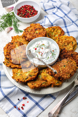 Image of Zucchini fritters with yogurt sauce for breakfast.