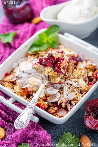 Image of Red plum crumble. Healthy breakfast.