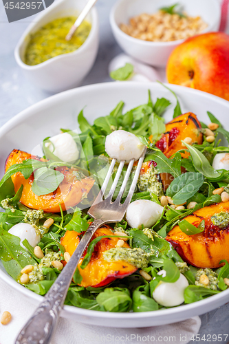 Image of Salad with arugula, nectarines and pesto sauce.