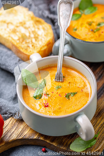 Image of Tomato soup with cream, spices and green basil.