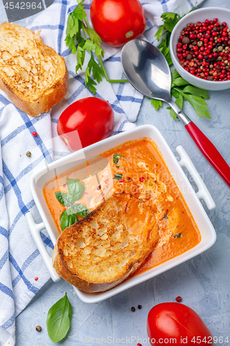 Image of Spicy tomato soup with green basil.