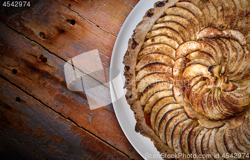 Image of Traditional french apple tart over brown planks