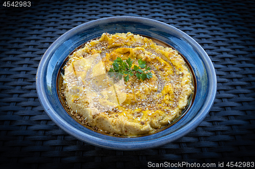 Image of Tasty hummus (or houmous) in blue bowl