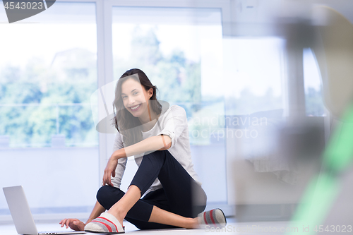 Image of young women using laptop computer on the floor