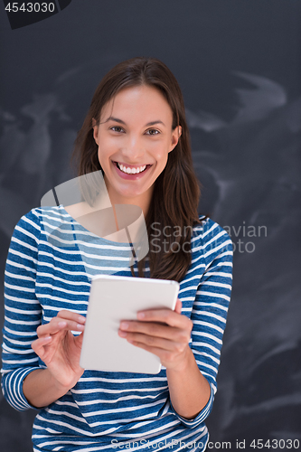 Image of woman using tablet  in front of chalk drawing board