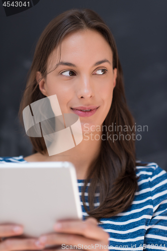 Image of woman using tablet  in front of chalk drawing board