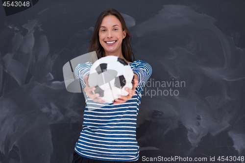 Image of woman holding a soccer ball in front of chalk drawing board