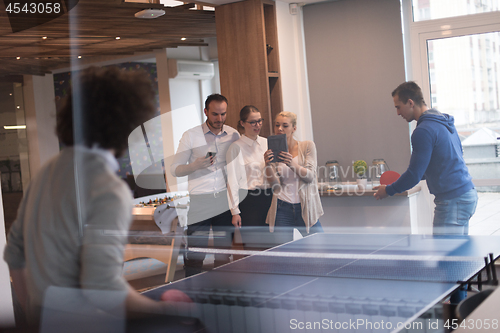 Image of startup business team playing ping pong tennis