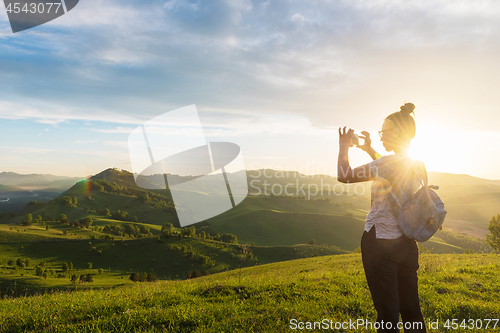 Image of Woman taking photo in mountain