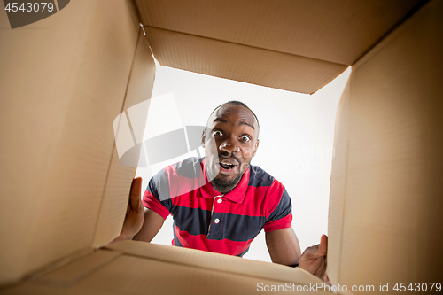 Image of Man unpacking and opening carton box and looking inside