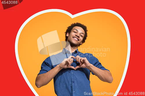 Image of The happy business man standing and smiling against orange background.