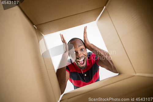 Image of Man unpacking and opening carton box and looking inside