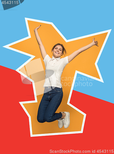 Image of Freedom in moving. Pretty young woman jumping against orange background