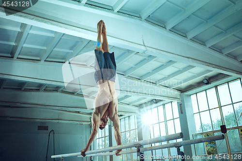 Image of The sportsman during difficult exercise, sports gymnastics