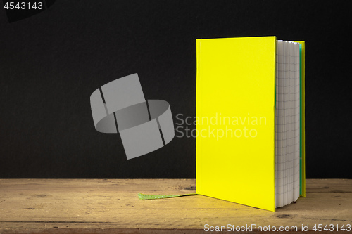 Image of a yellow green note book on a wooden table