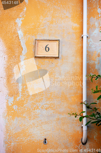 Image of orange painted wall with the number six