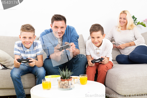 Image of Happy young family playing videogame On TV.