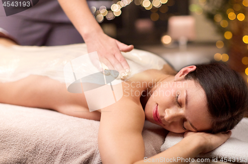 Image of woman lying and having back massage at spa