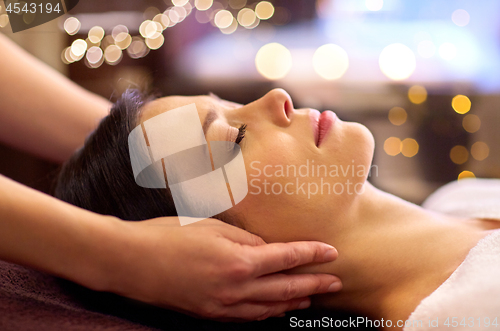 Image of woman having face and head massage at spa