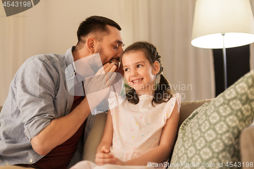 Image of happy father whispering secret to daughter at home