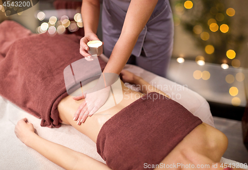 Image of woman lying and having massage with hot oil at spa