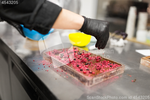 Image of confectioner makes chocolate dessert at sweet-shop