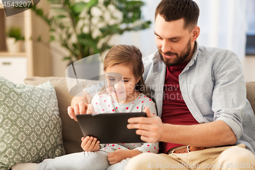 Image of father and daughter with tablet computer at home