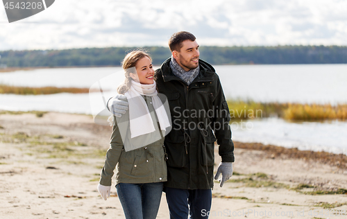 Image of couple walking along autumn beach