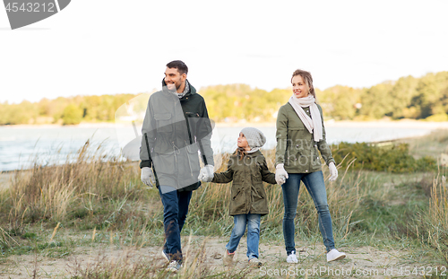 Image of happy family walking along autumn beach