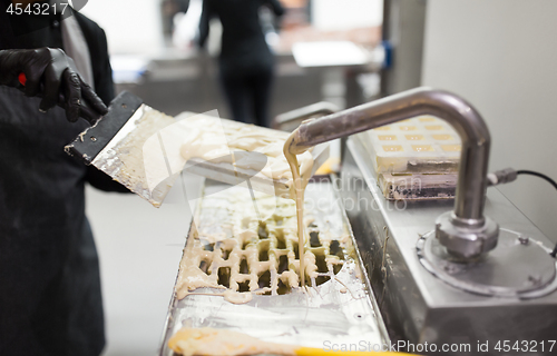 Image of confectioner makes chocolate candies at sweet-shop