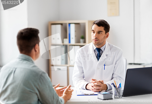 Image of doctor with laptop and male patient at hospital