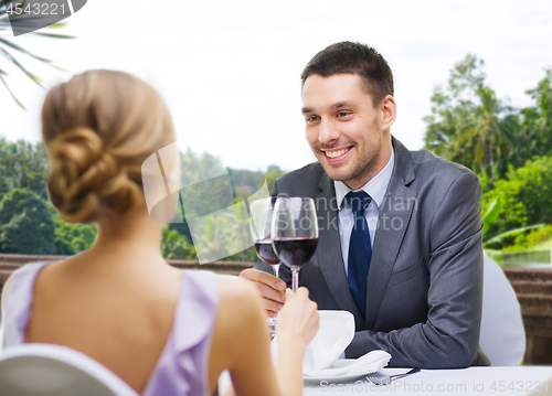 Image of young couple with glasses of wine at restaurant