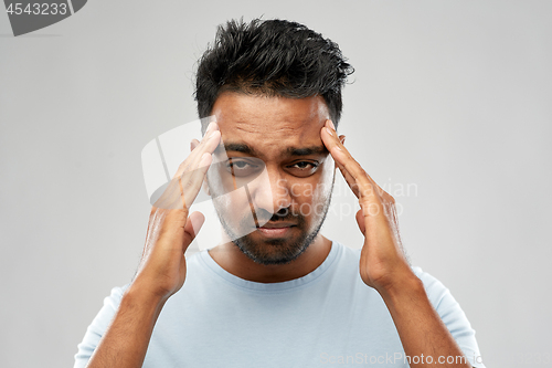 Image of unhappy indian man suffering from headache