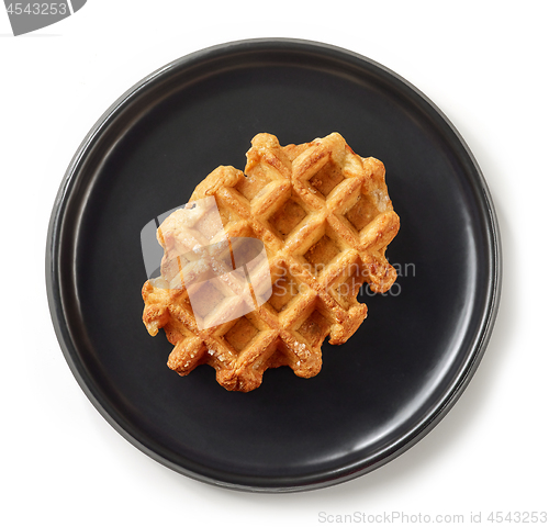 Image of freshly baked belgian waffle on black plate