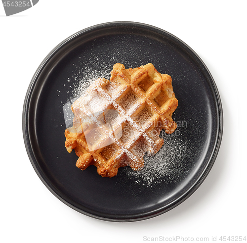 Image of freshly baked belgian waffle on black plate